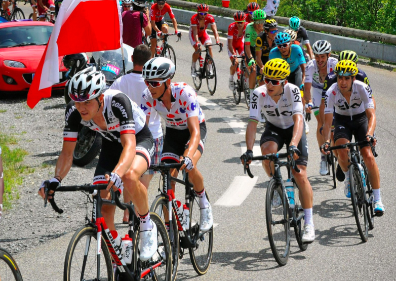 Bicycle racers in the Tour de France rounding a curve.